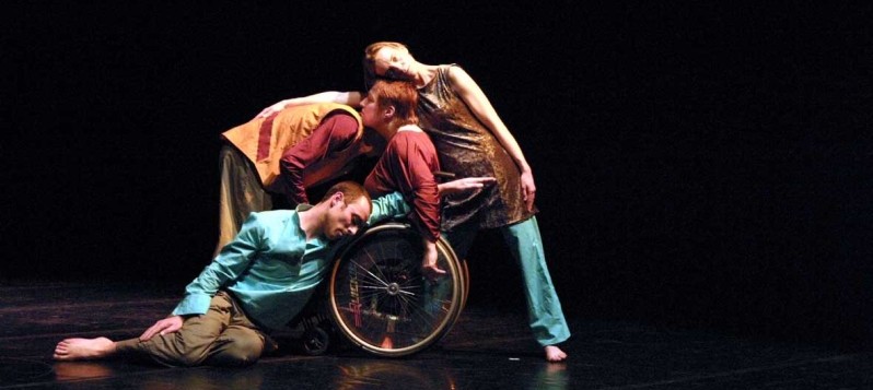 Das Ensemble ist um einen Rollstuhl herum ineinander verflochten.