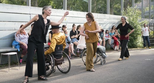 Strassenaufnahme des Stücks mit Zuschauern im Hintergrund.