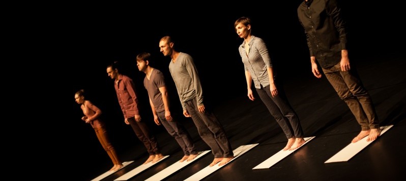 Eine Gruppe von sechs Personen steht in einer Reihe nebeneinander.